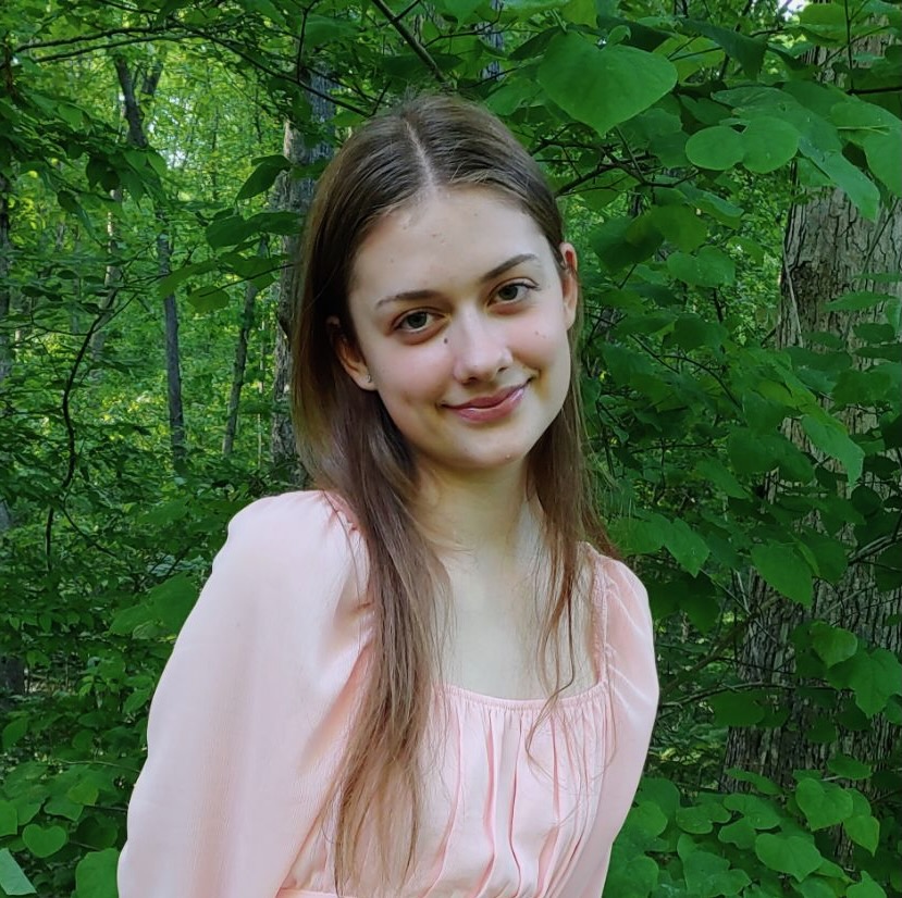 Dinah McKemie posing in front of trees.